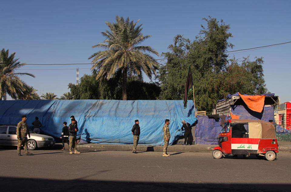 Iraqi security forces stand guard outside Tahrir Square where ongoing anti-government protests are taking place, in Baghdad, Iraq, Tuesday, Dec. 24, 2019. (AP Photo/Khalid Mohammed)