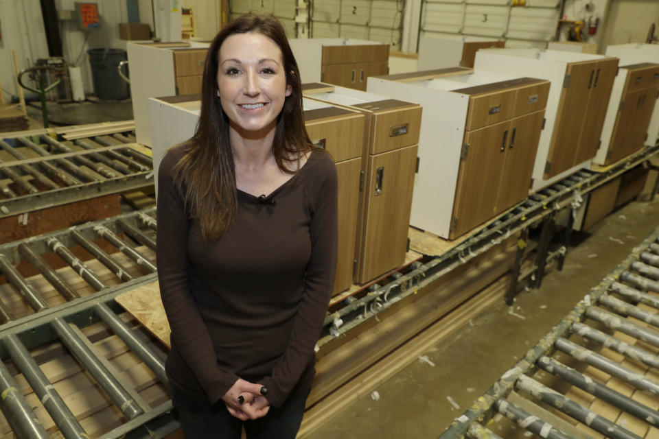 In this Nov. 14, 2019 photo, Jamie Cline poses for a photo in a cabinet-making area of Genothen, a millwork shop where she is employed in Tumwater, Wash. Cline, who in the past had used heroin for ten years, got the job and cleaned up other areas of her life once she started taking a prescription medication called buprenorphine that she got at a clinic in Olympia, Wash., where a doctor is working to spread a philosophy called "medication first." The surprising approach scraps requirements for counseling, abstinence or even a commitment to recovery. (AP Photo/Ted S. Warren)