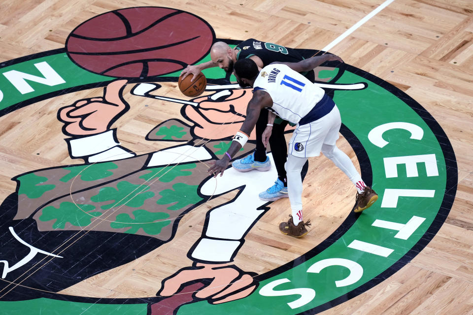 Dallas Mavericks guard Kyrie Irving defends Boston Celtics guard Derrick White as the cross center court during the second half of Game 2 of the NBA Finals basketball series, Sunday, June 9, 2024, in Boston. (AP Photo/Michael Dwyer)