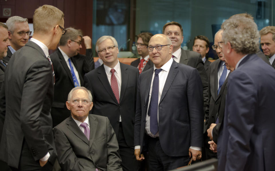 FILE - German Finance Minister Wolfgang Schaeuble, center left, speaks with Finland's Finance Minister Alexander Stubb, third left, and French Finance Minister Michel Sapin, center right, during a meeting of eurogroup finance ministers in Brussels on Saturday, June 27, 2015. Wolfgang Schaeuble, who helped negotiate German reunification in 1990 and as finance minister was a central figure in the austerity-heavy effort to drag Europe out of its debt crisis more than two decades later, has died on Tuesday, Dec. 26, 2023. He was 81. (AP Photo/Thierry Monasse, File)