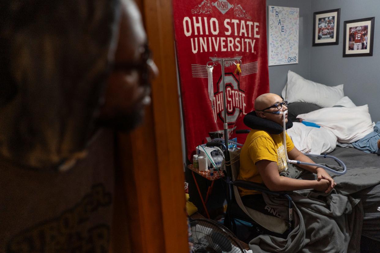 Tim Hawthorne, 51, peeks around the corner to check on his son Trae, 15, inside his bedroom at their home on Wednesday, March 27, 2024.