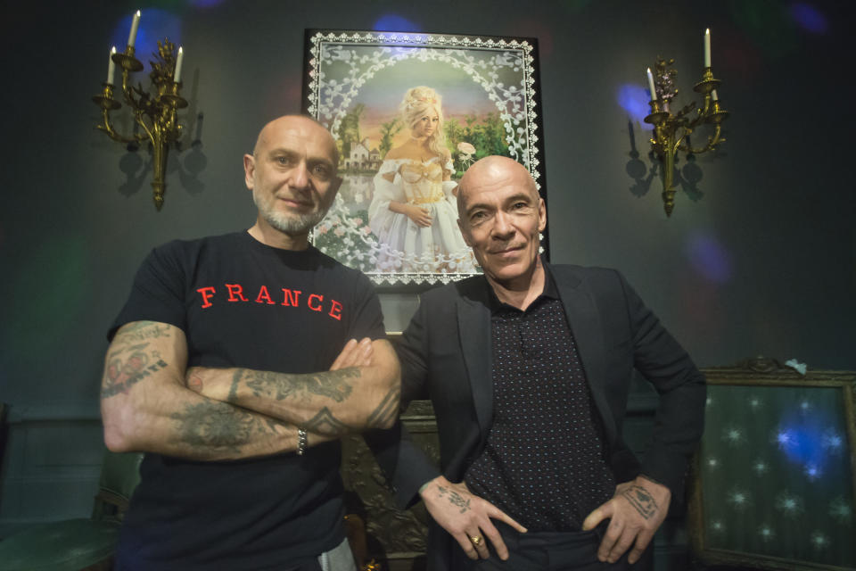 French artists Pierre Commoy, left, and Gilles Blanchard, known as Pierre et Gilles, pose inside their installation at the Gobelins Gallery in Paris, Monday, April 7, 2014. Pierre Commoy and Gilles Blanchard, who have established a strong reputation in Europe and beyond for shock ever since their stylized, hand-painted homoerotic photos first appeared nearly 40 years ago. Today, their iconic images of stars such as Madonna, Kylie Minogue, Mick Jagger and Catherine Deneuve which appear alongside naked gay porn stars in glittering and fantastical scenes line coffee-tables the world over and have titillated millions. (AP Photo/Michel Euler)