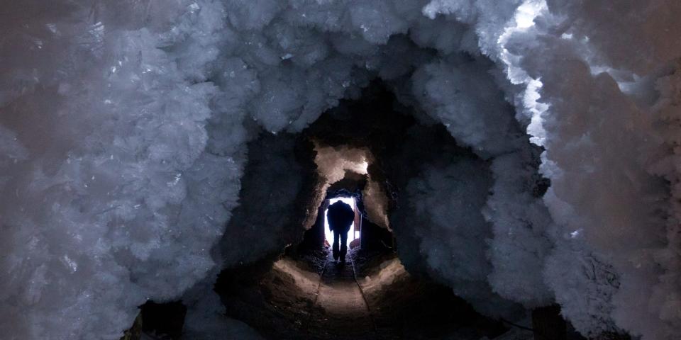 Ein Mann geht durch einen aus Permafrostkristallen geformten Tunnel außerhalb des russischen Dorfes Tomtor. - Copyright: Maxim Shemetov/REUTERS