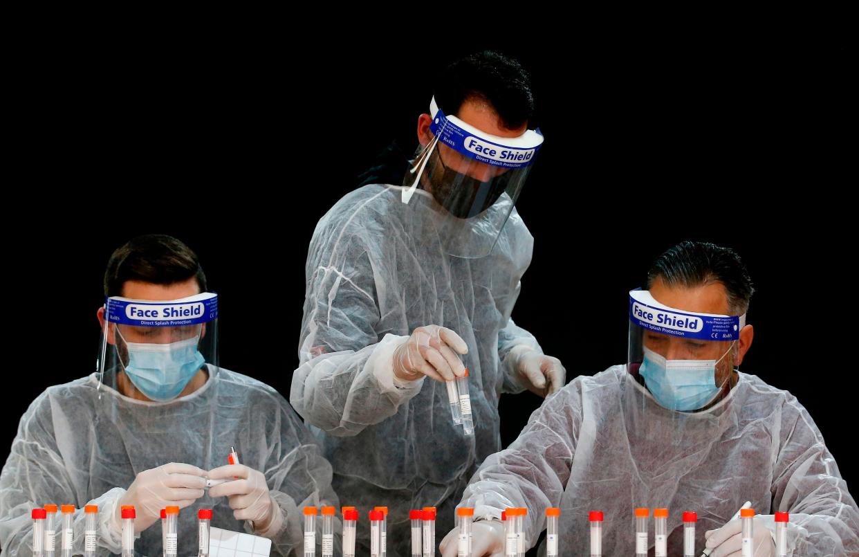 Palestinian health workers register samples for coronavirus testing in the West Bank village of Dura, southwest of Hebron, on January 8, 2021 (AFP via Getty Images)