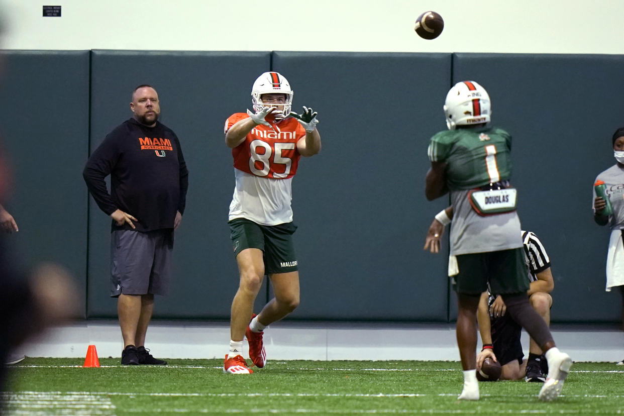 Miami tight end Will Mallory (85) prepares to catch a pass from quarterback D'Eriq King (1) during NCAA college football practice Tuesday, Aug. 10, 2021, in Coral Gables, Fla. (AP Photo/Lynne Sladky)