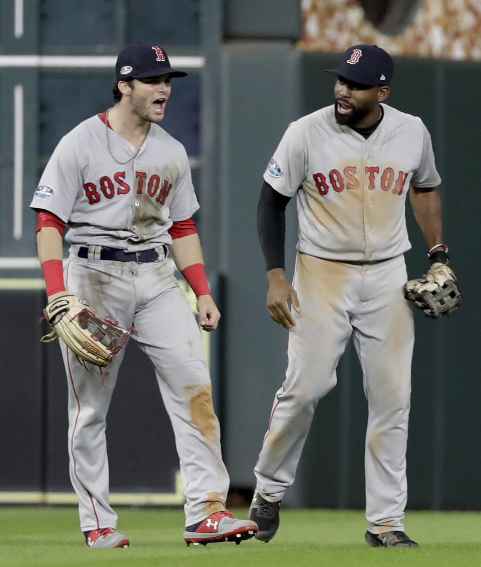 Boston Red Sox left fielder Andrew Benintendi, left, and center fielder Jackie Bradley Jr. celebrate their 8-6 win against the Houston Astros in Game 4 of a baseball American League Championship Series on Wednesday, Oct. 17, 2018, in Houston. (AP Photo/David J. Phillip)