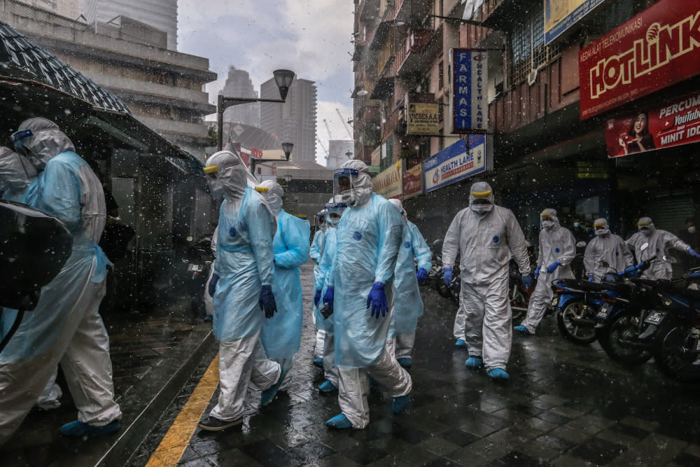 Health workers in protective suits are seen at Selangor Mansion in Jalan Masjid India April 6, 2020. —Picture by Firdaus Latif