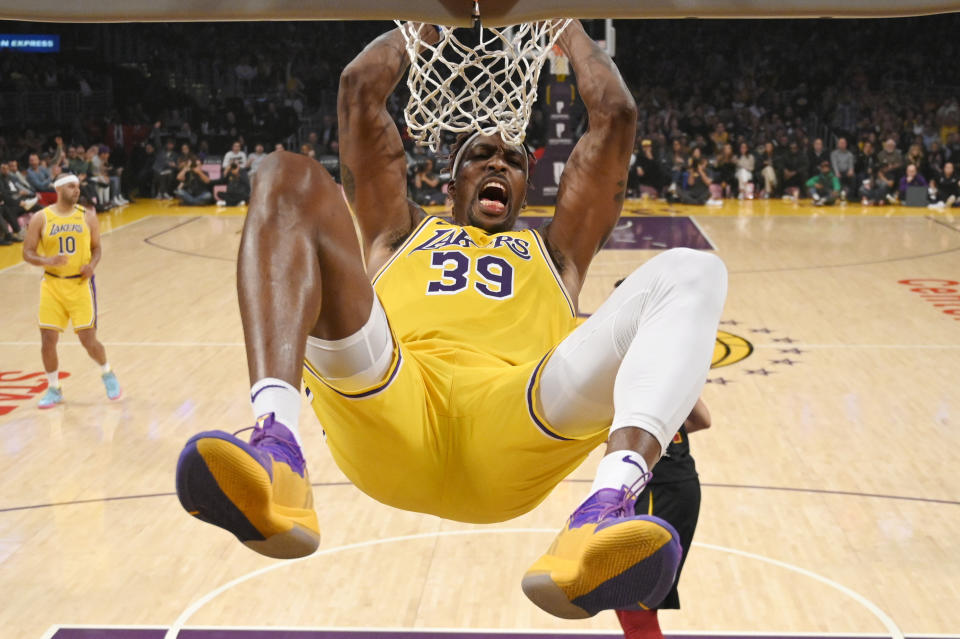Los Angeles Lakers center Dwight Howard hangs on the basket as he dunks during the first half of an NBA basketball game against the Cleveland Cavaliers Monday, Jan. 13, 2020, in Los Angeles. (AP Photo/Mark J. Terrill)