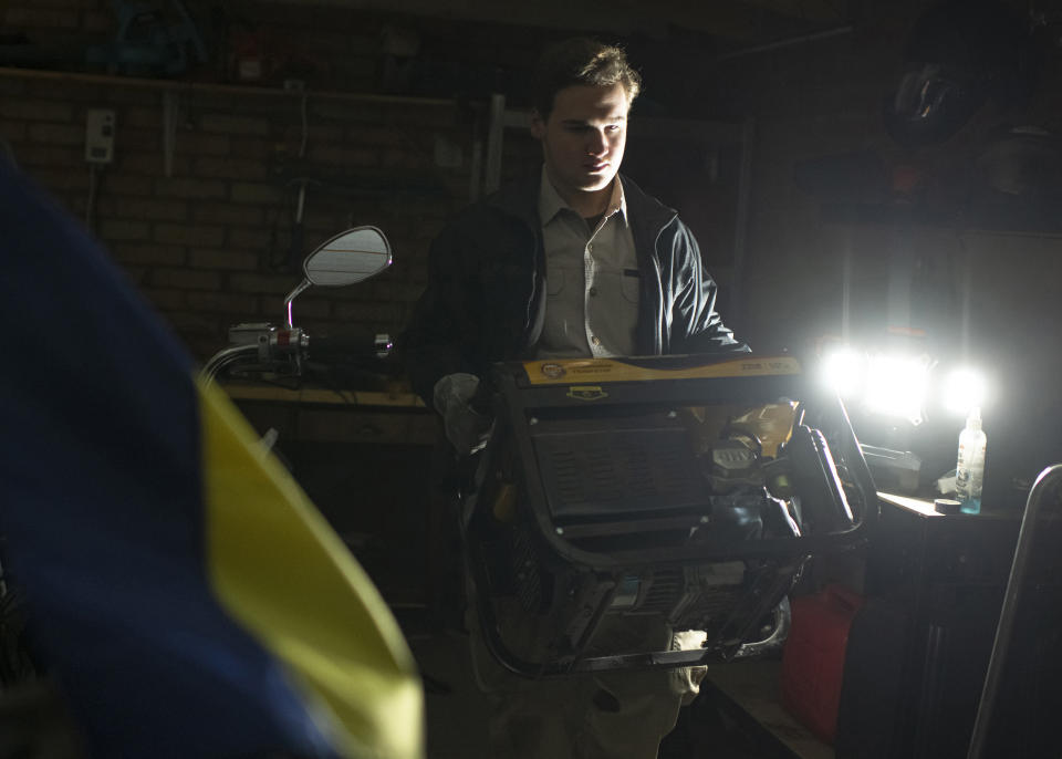 FILE - Local resident Danylo prepares a generator during a blackout in Kyiv, Ukraine, on Nov. 18, 2022. When Russian forces two months ago launched a military campaign against infrastructure in Ukraine, it opened an urgent second front far from the contact line: along power lines, water mains, and heating systems, and in places like homes, schools, offices and churches. (AP Photo/Andrew Kravchenko, File)