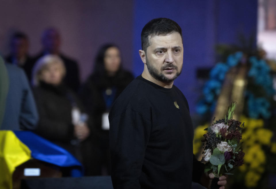 El presidente de Ucrania, Volodymyr Zelenskyy, presenta sus respetos a las víctimas de un accidente letal de helicóptero, en Kiev, Ucrania, el 21 de enero de 2023. (AP Foto/Efrem Lukatsky)