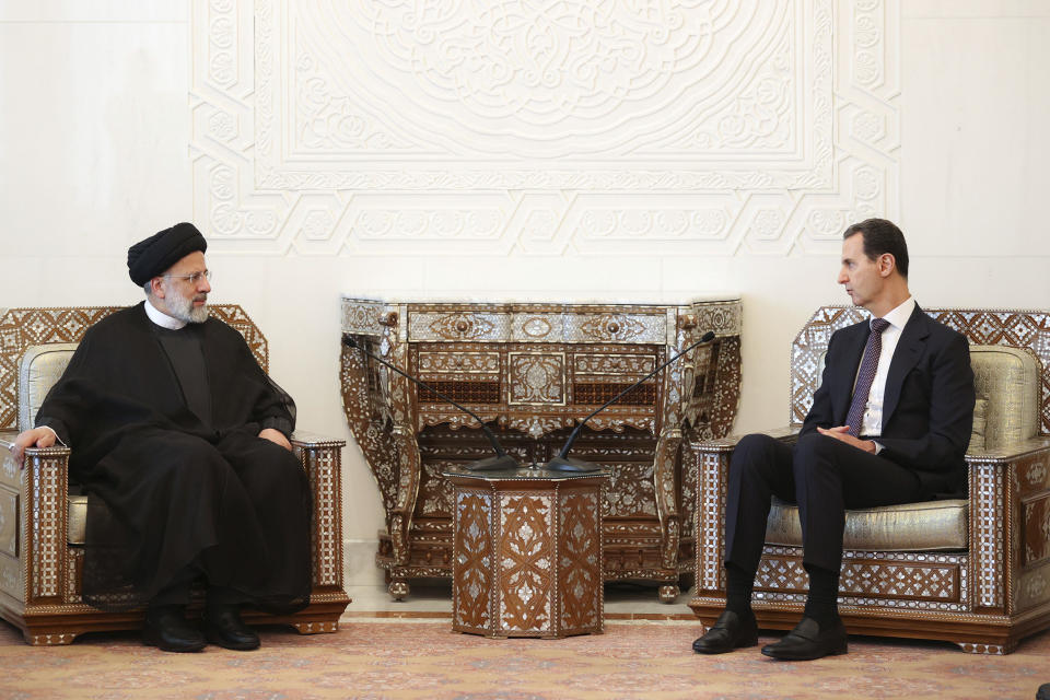 In this photo released by the office of the Iranian Presidency, President Ebrahim Raisi, left, listens to his Syrian counterpart Bashar Bashar Assad during their meeting in Damascus, Syria, Wednesday, May 3, 2023. (Iranian Presidency Office via AP)