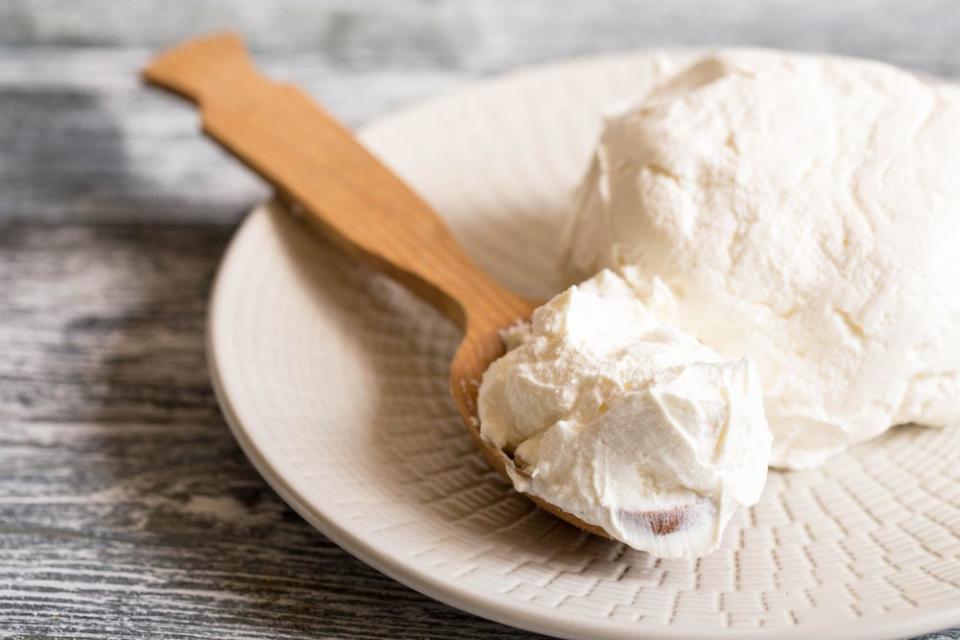 Traditional Mascarpone cheese in wooden spoon