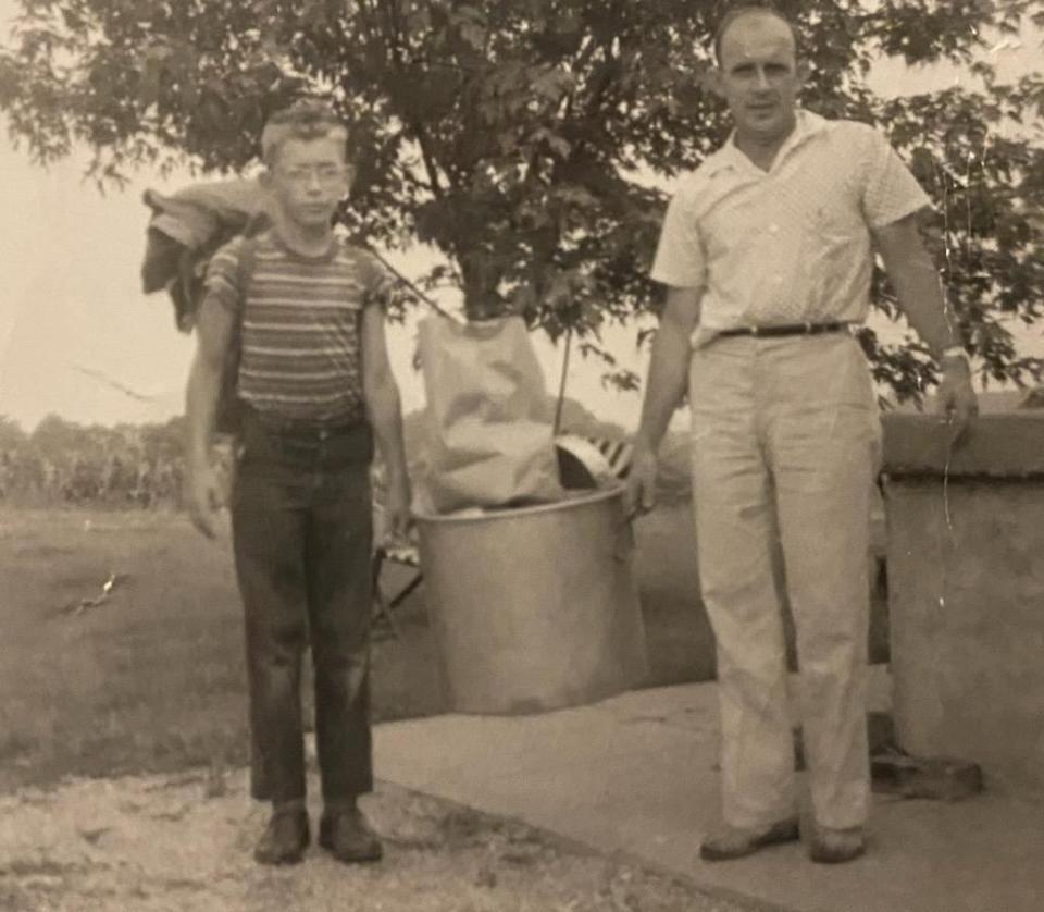 a couple of men standing next to a barrel