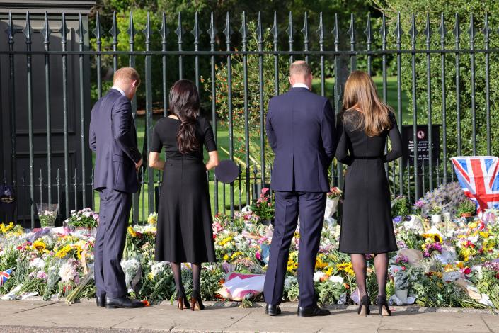Prince Harry, Meghan Markle, Prince William, and Kate Middleton look at floral tributes