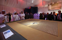 Emaratis and foreigners look at a model of the Shams 1, Concentrated Solar power (CSP) plant, in al-Gharibiyah district on the outskirts of Abu Dhabi, on March 17, 2013 during the inauguration of the facility. (MARWAN NAAMANI/AFP/Getty Images)