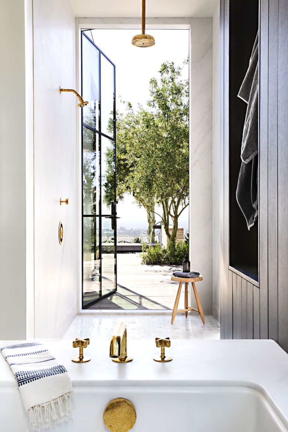 <p>When you have a home that overlooks the Pacific Ocean, you want to make the most of it—even in the bathroom. <a href="https://www.housebeautiful.com/design-inspiration/house-tours/a28900705/eric-olsen-corona-del-mar-california-home/" rel="nofollow noopener" target="_blank" data-ylk="slk:Eric Olsen;elm:context_link;itc:0;sec:content-canvas" class="link ">Eric Olsen</a> added this glass door (which leads to an outdoor shower!) off the main bath of his California home. </p>