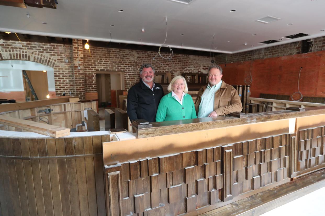 Tim Strickland, Jennifer Strickland, and Chris Swanson owners of the Wexford Irish Pub stand behind the bar that is currently being assembled on the 2nd floor.