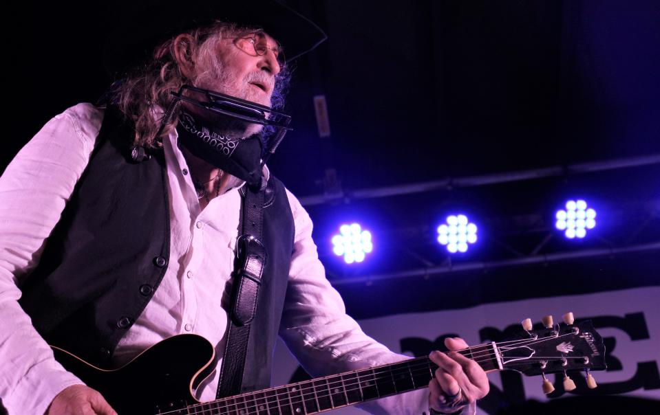 Ray Wylie Hubbard looks across the stage April 23, 2022, toward his son, Lucas, who was playing guitar at his father's show in the courtyard at Froniter Texas!