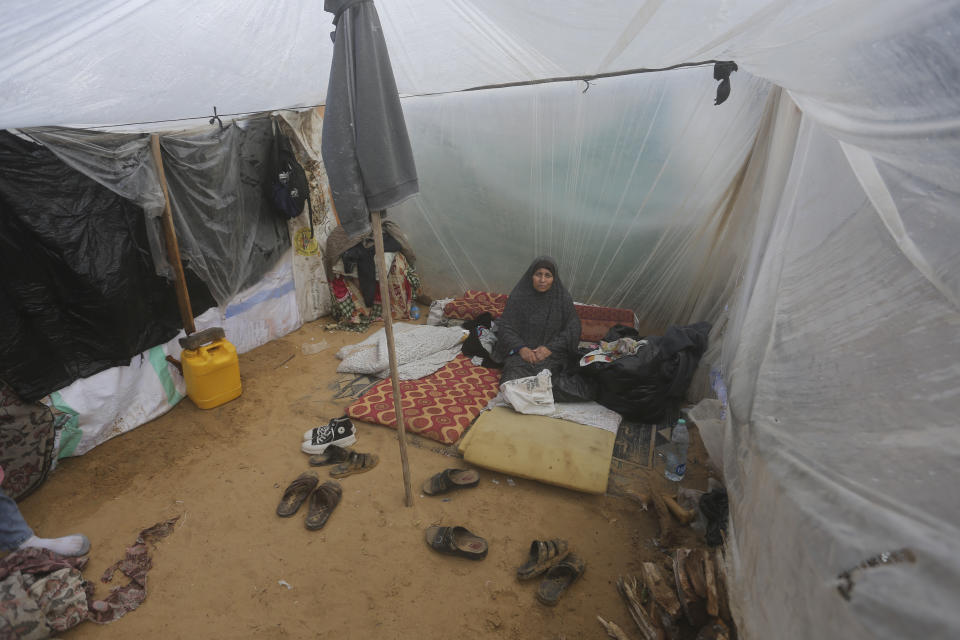 A Palestinian woman displaced by the Israeli bombardment sits in a makeshift tent in Rafah, Gaza Strip, Tuesday, Jan. 2, 2023. (AP Photo/Hatem Ali)