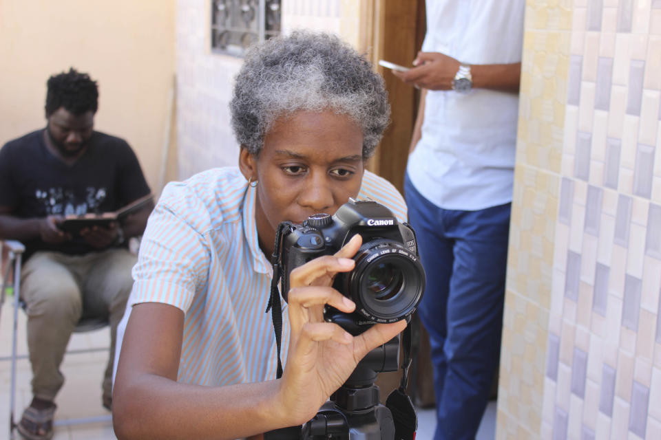 This Nov. 20, 2018, photo shows filmmaker Tuleka Prah, the founder of My African Food Map, at work in Ngaparou, Senegal. In the quiet hours before lunch, two women worked side by side in an airy kitchen. One, a chef, cleaned fresh red snapper filets with a sharp knife. The other, a filmmaker, pointed her camera into a large pot of simmering vegetables. (AP Photo/Amelia Nierenberg)