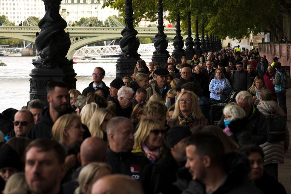 People wait in a queue opposite Westminster Palace to pay their respect to the late Queen Elizabeth II during the Lying-in State, in Westminster Hall, London, Friday, Sept. 16, 2022.