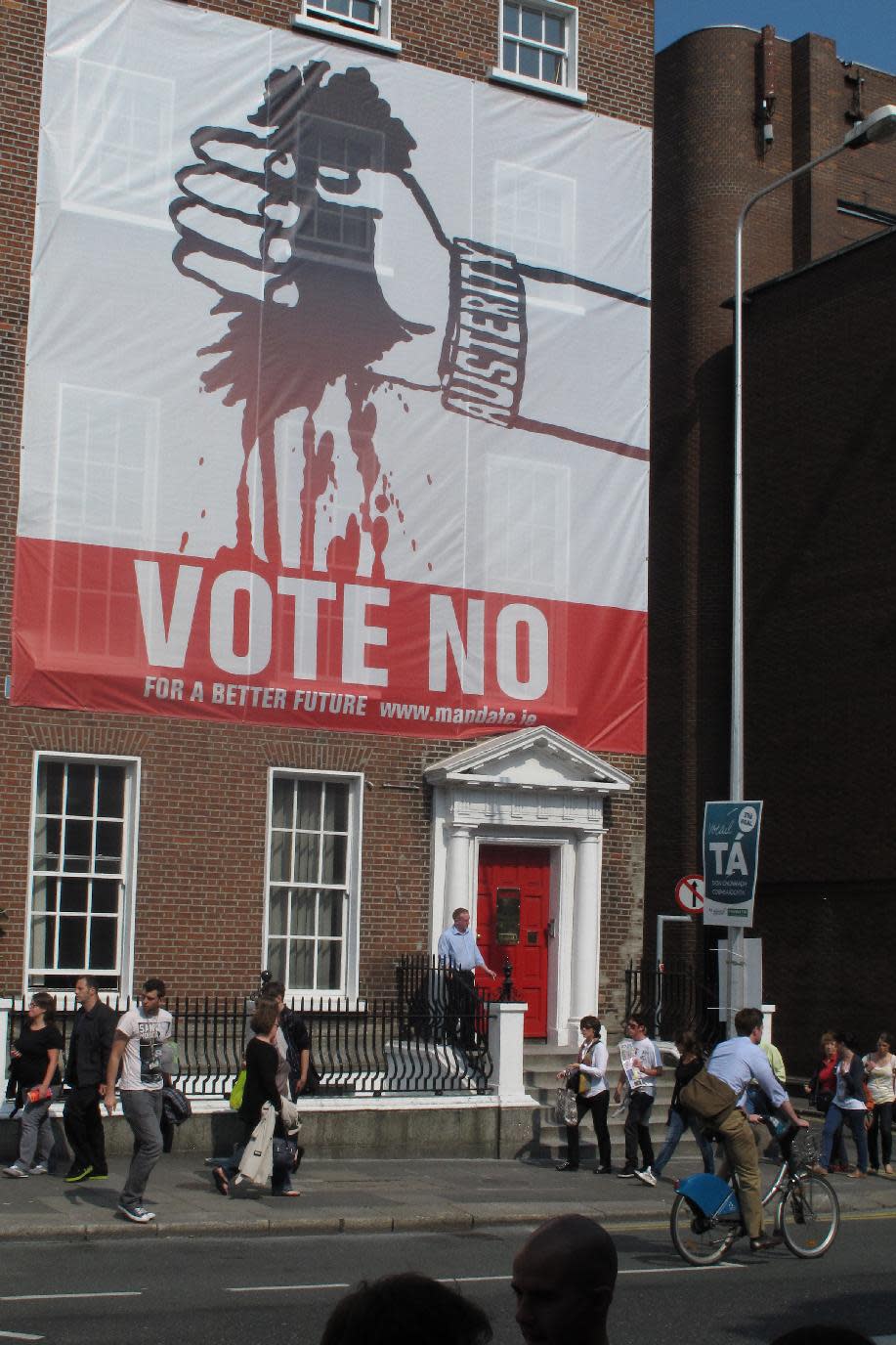 A huge banner depicting Ireland being bled dry by austerity calls for a "no" vote to the European Union's fiscal treaty in Dublin, Ireland, on Friday, May 25, 2012. A much smaller placard, lower right, appeals for ``ta'' _ Gaelic for ``yes.'' Ireland's May 31 referendum represents the only popular test of public support for the treaty, which is designed to restrict the ability of eurozone members to run up deficits. Prime Minister Enda Kenny made a televised appeal to his nation Sunday to support the treaty, arguing it would reassure the world that Ireland is serious about tackling its deficits and staying in the euro. (AP Photo/Shawn Pogatchnik)