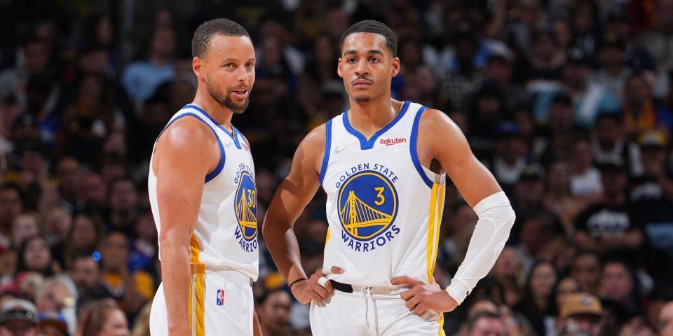 Stephen Curry and Jordan Poole stand next to each other during a Warriors playoff game in 2022.