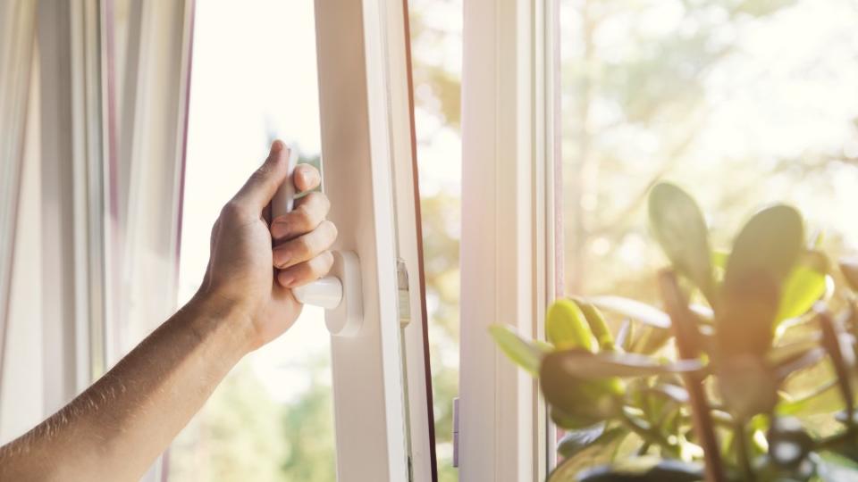 Un hombre abriendo una ventana