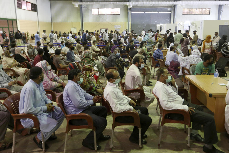 People wait their turn to receive the first shot the Sinovac COVID-19 vaccine at a vaccination center, in Karachi, Pakistan, Friday, June 4, 2021. (AP Photo/Fareed Khan)