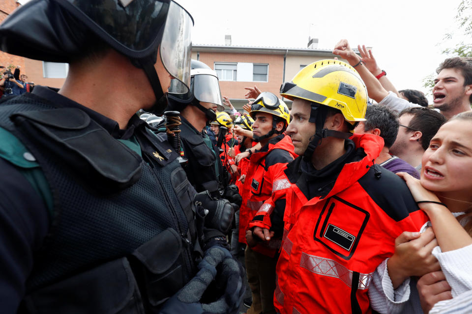 Firemen and people face off Spanish Civil Guard officers outside a polling station for the banned independence referendum in Sant Julia de Ramis, Spain Oct. 1, 2017. (Photo: Juan Medina / Reuters)