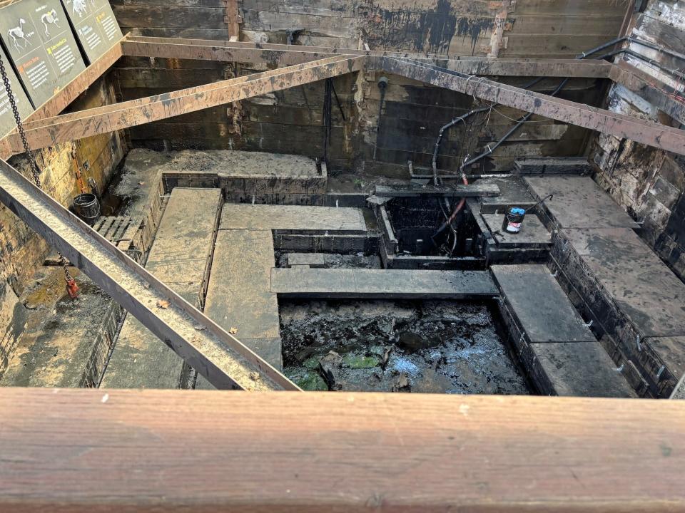 A tar pit with wooden planks around it and signs about large mammals found within