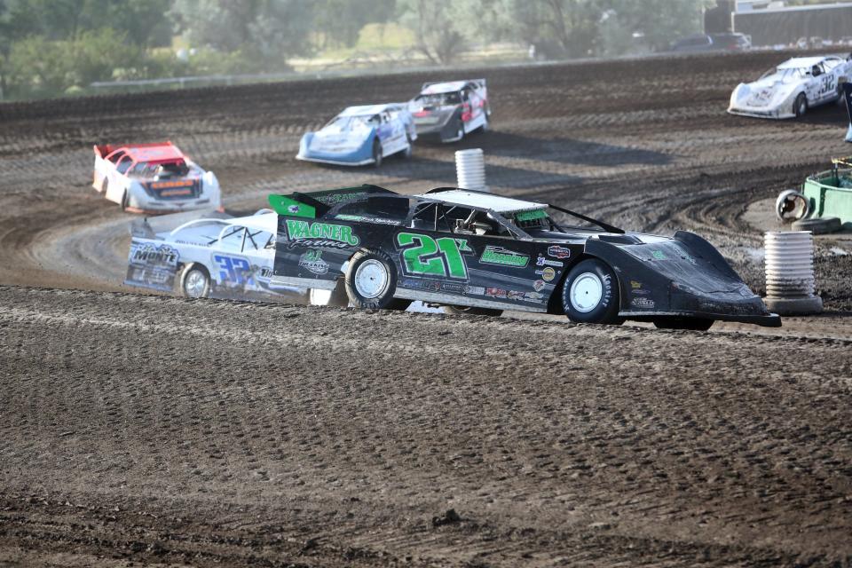 Dustin Arthur (21X) of St. Lawrence turns a corner ahead of other drivers during a late model heat race at the Dacotah Insurance Rumble Friday at the Brown County Speedway.