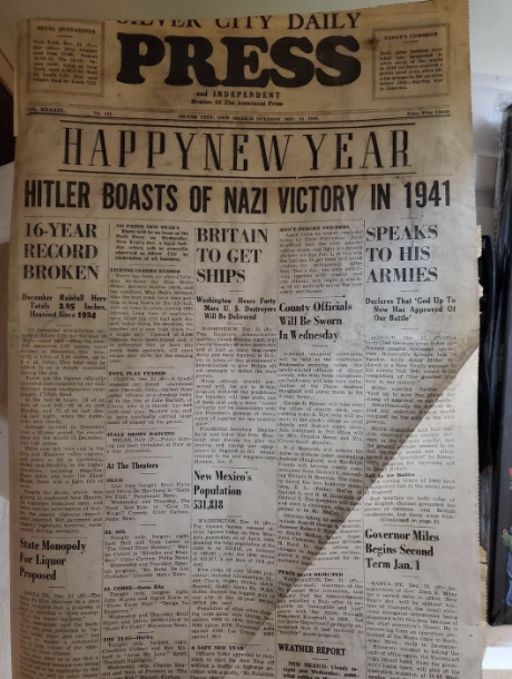 A newspaper front page from New Year's Day features prominent headlines about WWII, such as "Hitler Boasts of Nazi Victory in 1941" and "16-Year Record Broken."