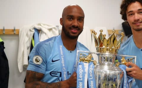 Fabian Delph (L) and Philippe Sandler of Manchester City celebrates with trophy in the Manchester City dressing room after winning the Premier League title following the match between Brighton & Hove Albion and Manchester City - Credit: GETTY IMAGES