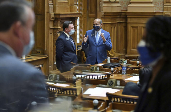FILE - In this Tuesday, Jan. 12, 2021, file photo, State Sens. Clint Dixon, rear left, and Sheikh Rahman, D-Lawrenceville, confer inside the Senate Chambers during the second day of the 2021 legislative session at the Georgia State Capitol, in Atlanta. Dixon, who represents a competitive district in the Atlanta suburbs, says he is disappointed that some conservative bills didn’t pass in the 2021 General Assembly, but added “there is a balance you’ve got to strike.” (Hyosub Shin/Atlanta Journal-Constitution via AP, File)
