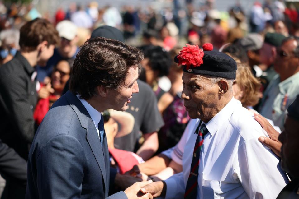 Prime Minister Justin Trudeau speaks with a descendant during the national apology to the No. 2 Construction Battalion in Truro, N.S. on July 9, 2022. THE CANADIAN PRESS/Riley Smith