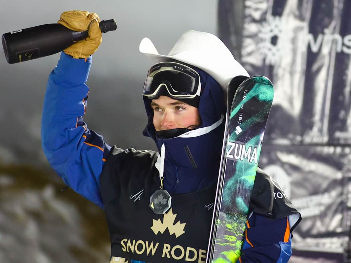 Brendan Mackay celebrates his gold medal on the podium in the men's World Cup freestyle ski halfpipe event in his hometown of Calgary on Thursday. (Evan Buhler/The Canadian Press - image credit)