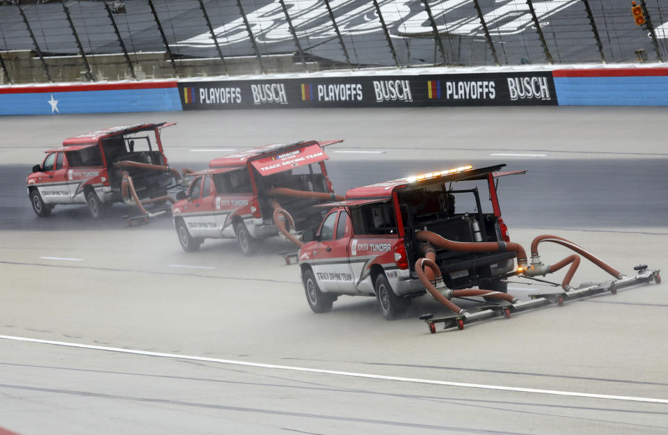 Drying trucks continue to prepare the track for a possible NASCAR Cup Series auto race at Texas Motor Speedway in Fort Worth, Texas, Tuesday, Oct. 27, 2020. The race was stopped on Sunday because of drizzle and misty conditions that allowed drivers to complete just 52 of 334 laps. Another 115 laps have to be completed to get to the halfway mark of 167 laps that would make Texas an official race. (AP Photo/Richard W. Rodriguez)