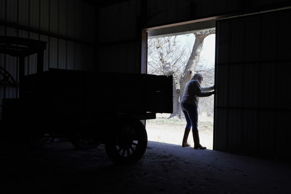 Alice Ball Strunk, president of the Devils River Conservancy, closes a barn door on her ranch near Del Rio, Texas, Thursday, Feb. 16, 2023. Strunk's property is adjacent to a proposed wind development. (AP Photo/Eric Gay)