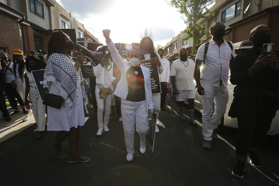 MOVE member Pam Africa leads a group along the 6200 block of Osage Avenue in Philadelphia, Thursday, May 13, 2021, on the 36th anniversary of the MOVE bombing and the city's first official day of remembrance for MOVE. In 1985, the police bombed the group’s headquarters, igniting fuel for a generator and spread to more than 60 rowhomes, killing 11 people including five children. (Yong Kim/The Philadelphia Inquirer via AP)