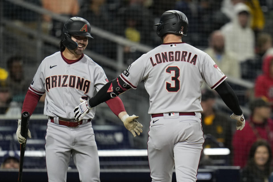 Arizona Diamondbacks' Evan Longoria (3) is greeted by teammate Corbin Carroll after hitting a home run during the ninth inning of a baseball game against the San Diego Padres, Monday, April 3, 2023, in San Diego. (AP Photo/Gregory Bull)