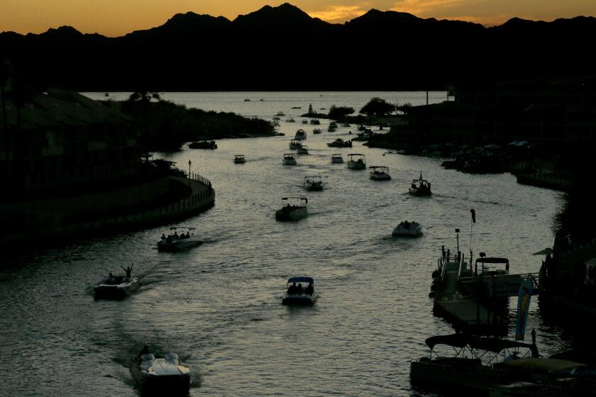 LAKE HAVASU CITY, ARIZ. - MAY 16, 2022. Boaters navigate a channel that separates Lake Havasu City from Lake Havasu Island, which are situated in a reservoir of Colorado River water created by the Parker Dam. Lake Havasu stores water for large population areas in Arizona and California, and its water does not vary more than 5 feet in depth from year to year. (Luis Sinco / Los Angeles Times)