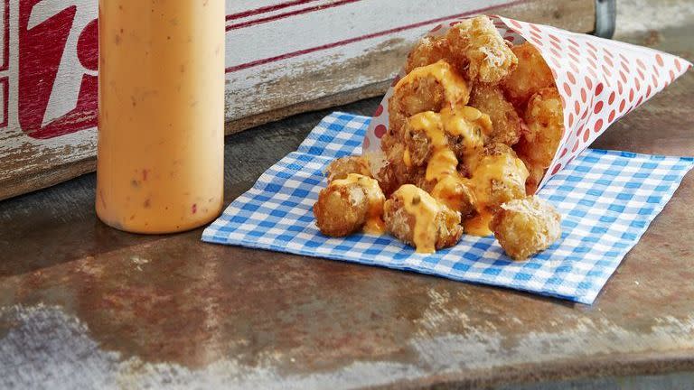parmesan tots in paper cones and drizzled with dipping sauce