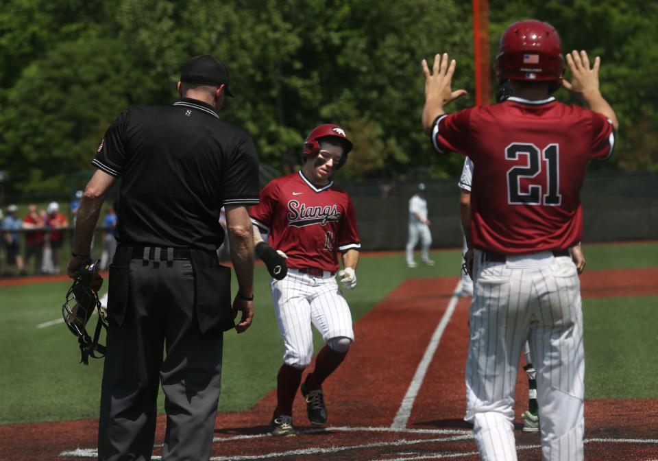 McCracken’s Nate Lang comes in for the score against Trinity.May 14, 2022