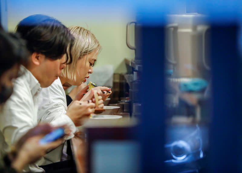 Customers eat ramen noodles inside a ramen noodle shop 'Shirohachi' managed by sixty-year-old Yashiro Haga, amid the coronavirus disease (COVID-19) outbreak, in Tokyo