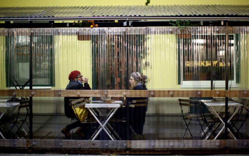 People sit at a table of an abandoned restaurant during the second lockdown as the coronavirus disease (COVID-19) outbreak continues in Vienna