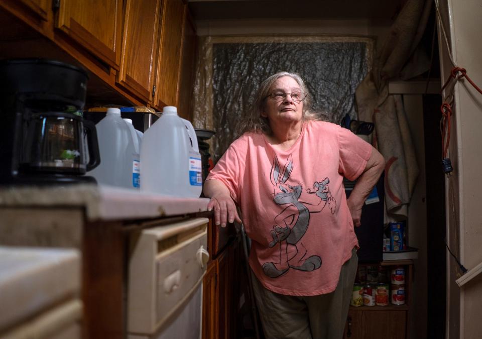 Flint resident Carol Sewell stands in the kitchen of her home on the city's south side with jugs of water she uses for drinking. Sewell wrote the judge a letter expressing unhappiness with the Flint water settlement and says she has a lead-tainted water heater she still can't afford to replace. No Flint residents have been paid, though lawyers and settlement administrators have already been paid tens of millions.