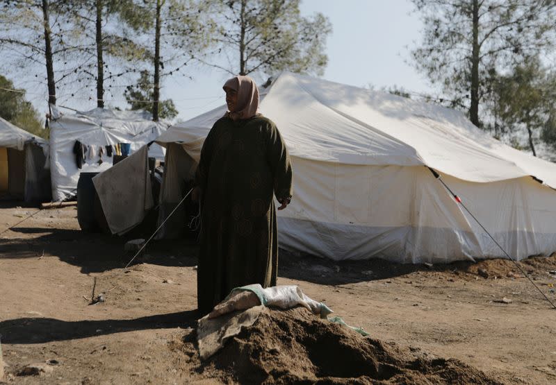 Aziza Hadaja, an internally displaced woman, stands outside tents near the town of Afrin