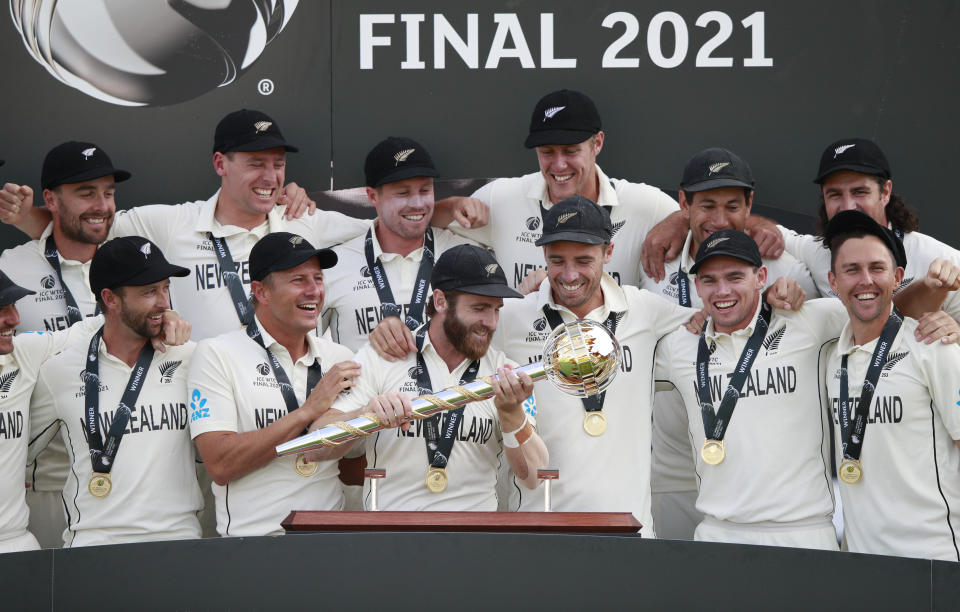 New Zealand players celebrate with the winners trophy after their win in the World Test Championship final cricket match against India, at the Rose Bowl in Southampton, England, Wednesday, June 23, 2021. New Zealand won the match by eight wickets. (AP Photo/Ian Walton)