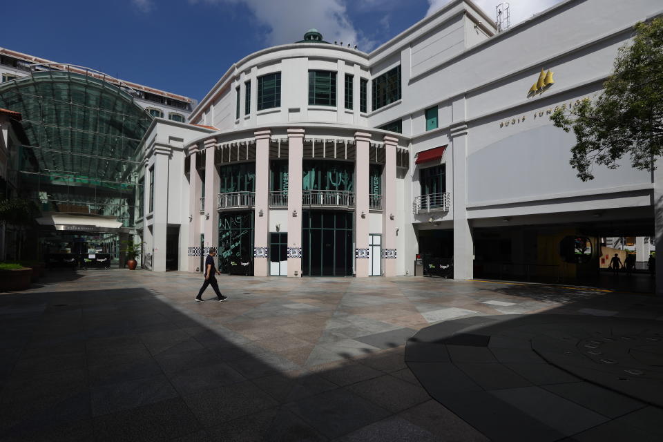 SINGAPORE - APRIL 19:  A man wearing a protective mask walks past an almost empty Bugis Junction shopping mall on April 19, 2020 in Singapore. Singapore recorded a daily high of 942 new coronavirus (COVID-19) cases on April 18, bringing the country's total to 5,992.  (Photo by Suhaimi Abdullah/Getty Images)